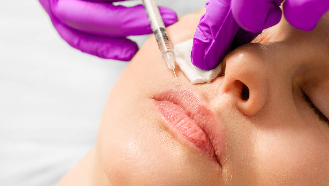 A photo of lips being injected with filler.